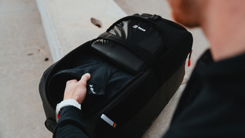 Close-up of LVRY CRRY gear bag as driver organizes racing suit and accessories inside.
