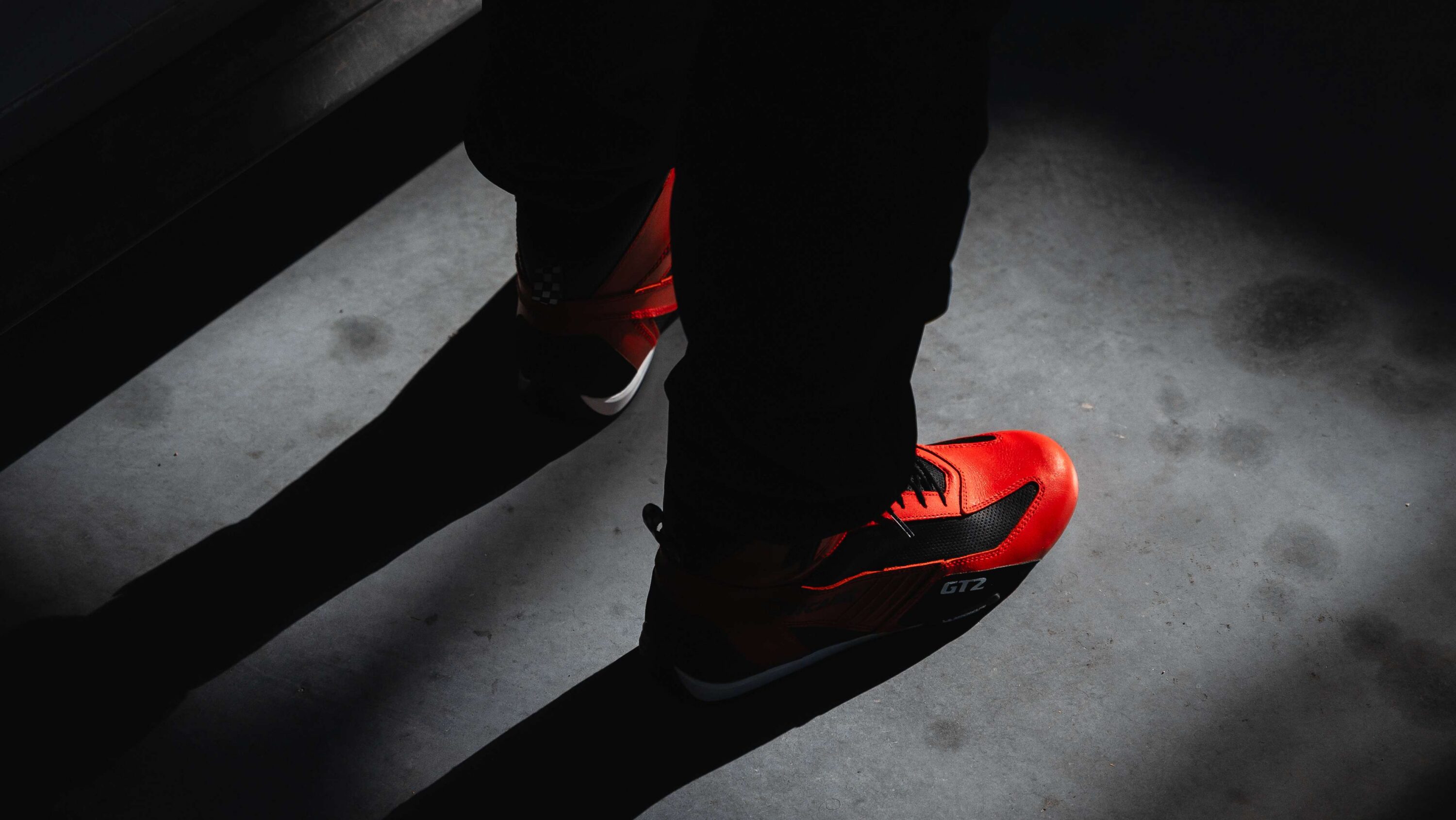 Close-up of red LVRY Chicane GT2 racing footwear highlighting performance construction for throttle and brake modulation.